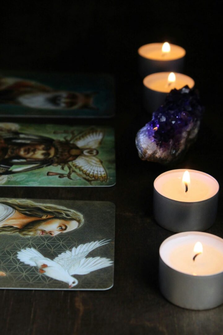 anne-nygard-si5pz0siQVM-unsplash (1) A table with candles and tarot cards on it.