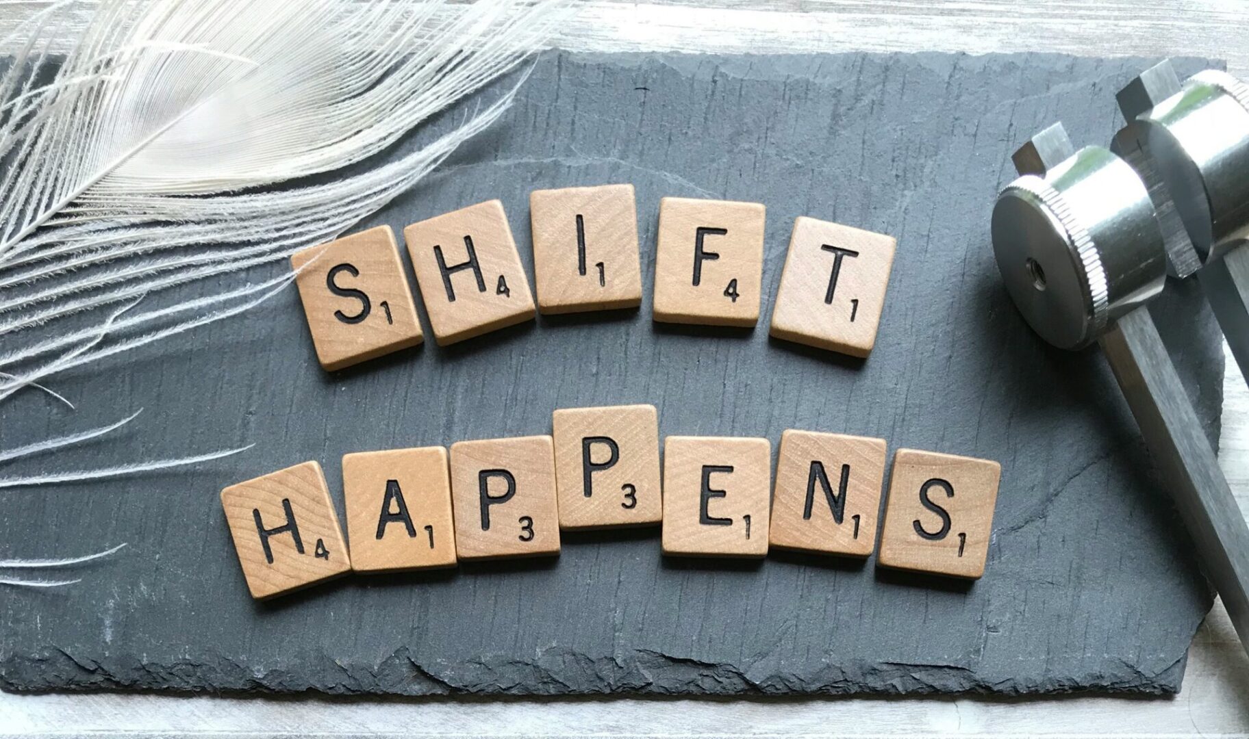 soulsana-V5DBwOOv0bo-unsplash A slate with scrabble tiles that spell " shift happens ".